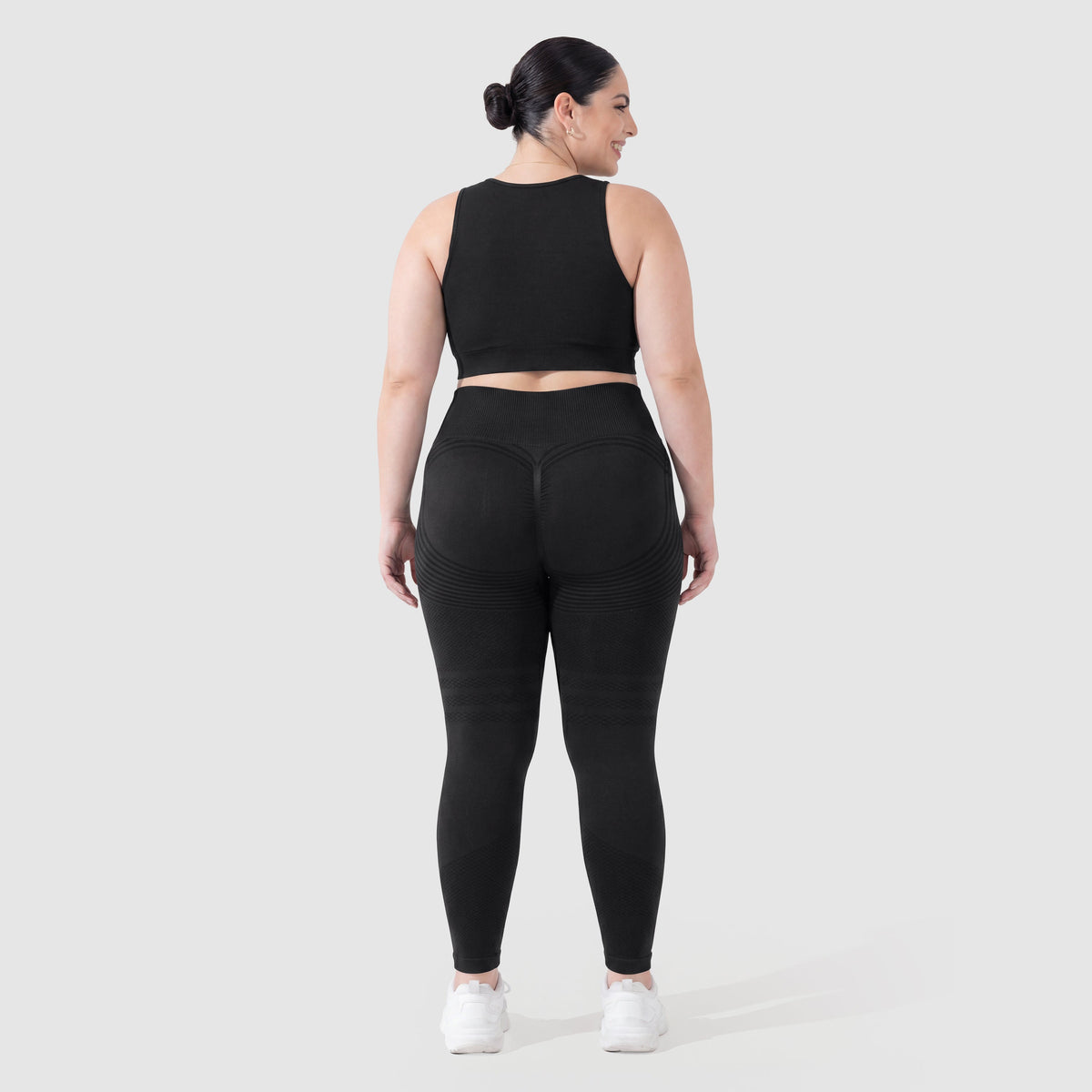 Kvinna i Sculpt 3D™ anticellulitleggings i svart, bakifrån, lyft och formad rumpa