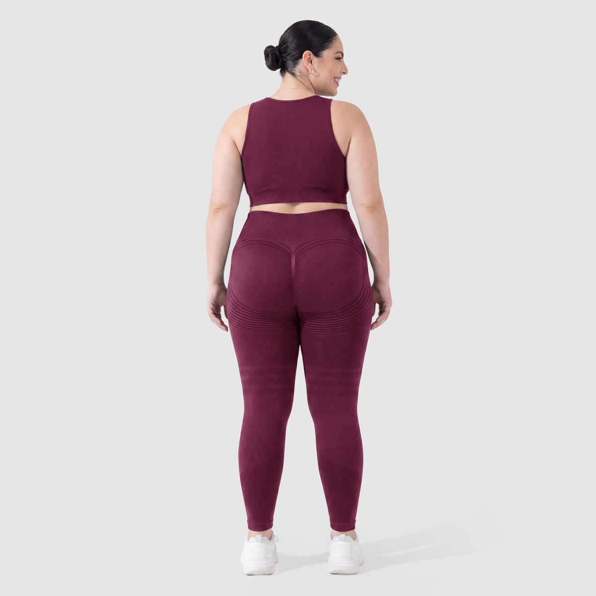 Kvinna i Sculpt 3D™ anticellulitleggings i plommon, bakifrån, lyft och formad rumpa