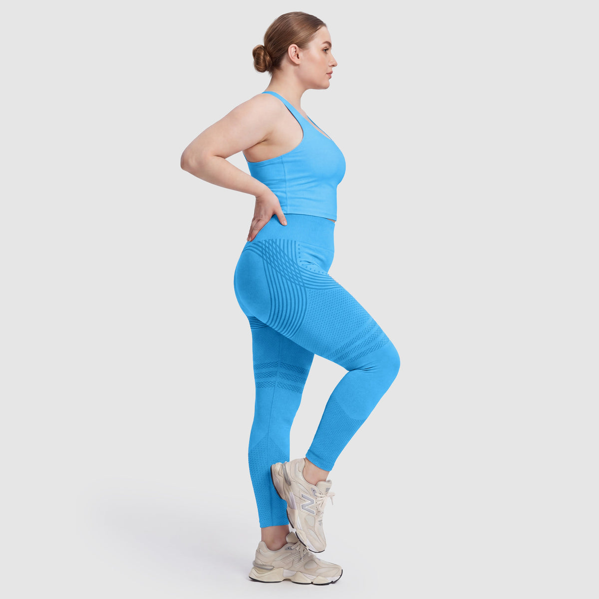 Kvinna i Sculpt 3D™ anticellulitleggings i turkos, från sidan, med de formande 3D-linjerna synliga