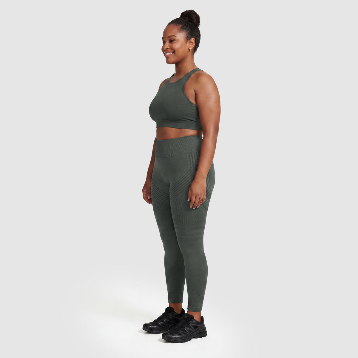Kvinna i Sculpt 3D™ anticellulitleggings i grått, från sidan, med de formande 3D-linjerna synliga