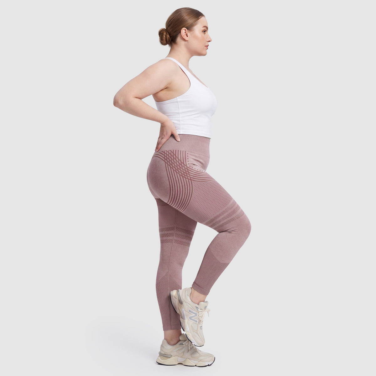 Kvinna i Sculpt 3D™ anticellulitleggings i rosa, från sidan, med de formande 3D-linjerna synliga