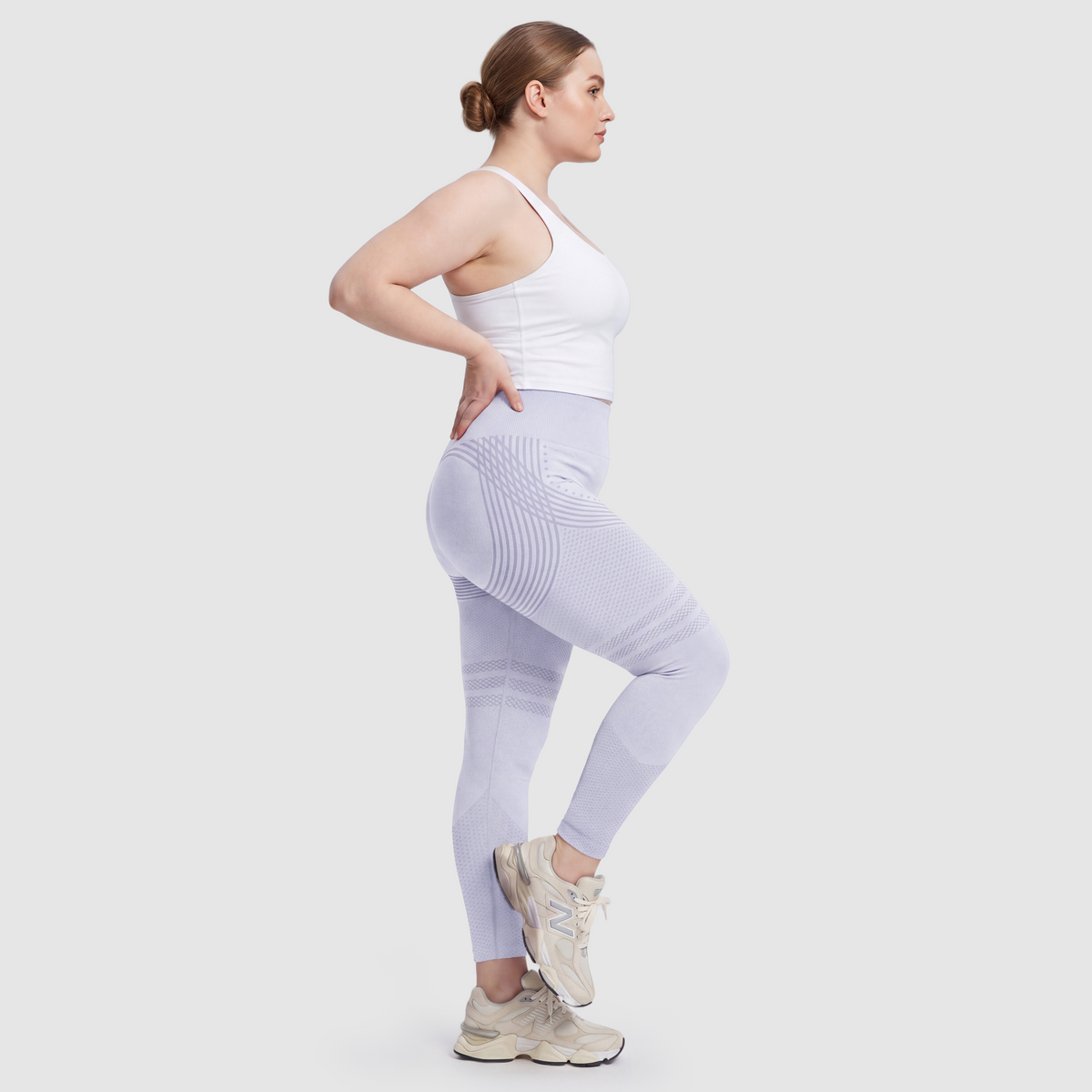 Kvinna i Sculpt 3D™ anticellulitleggings i ljusblått, från sidan, med de formande 3D-linjerna synliga