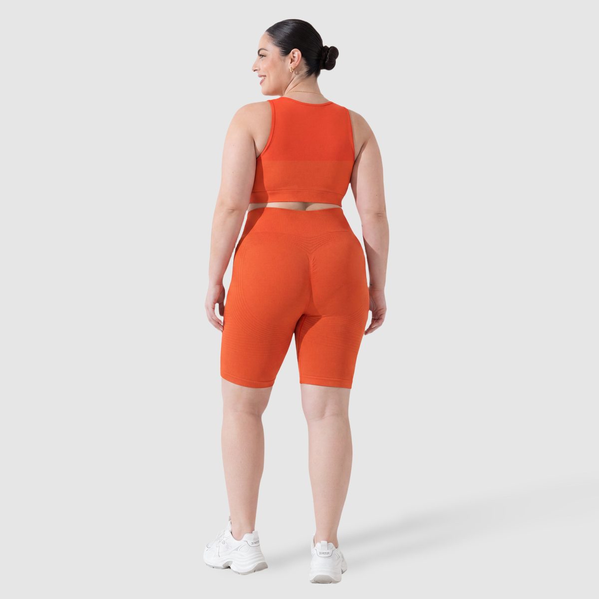 Kvinna i Sculpt 3D™ anticellulitshorts i orange, bakifrån, lyft och formad rumpa