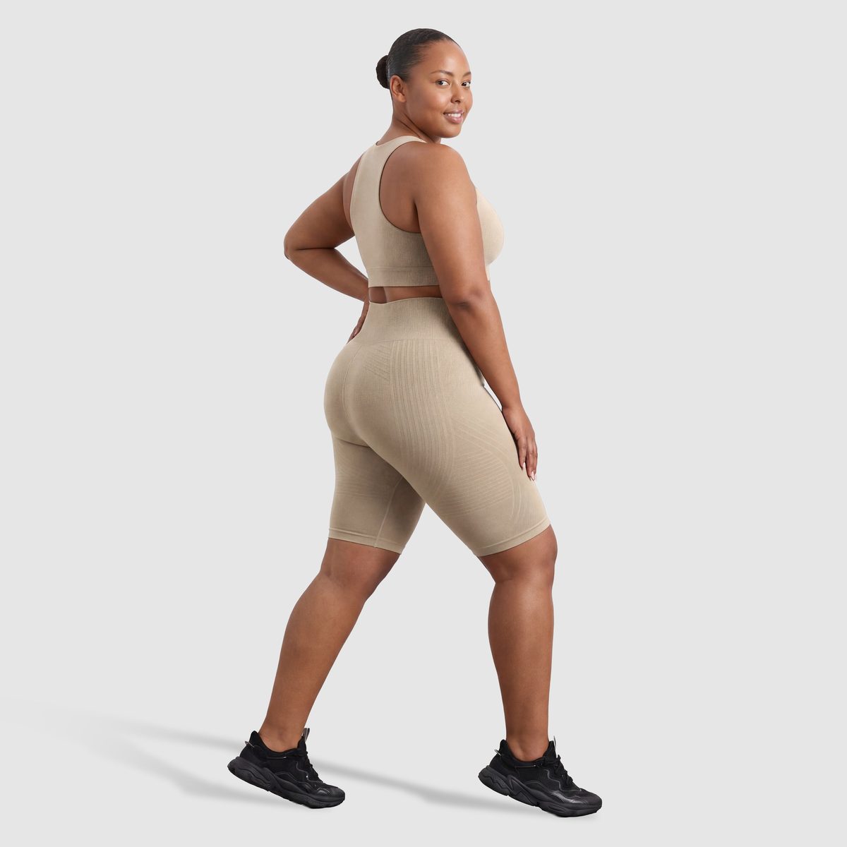 Kvinna i Sculpt 3D™ anticellulitshorts i beige, från sidan, med de formande 3D-linjerna synliga