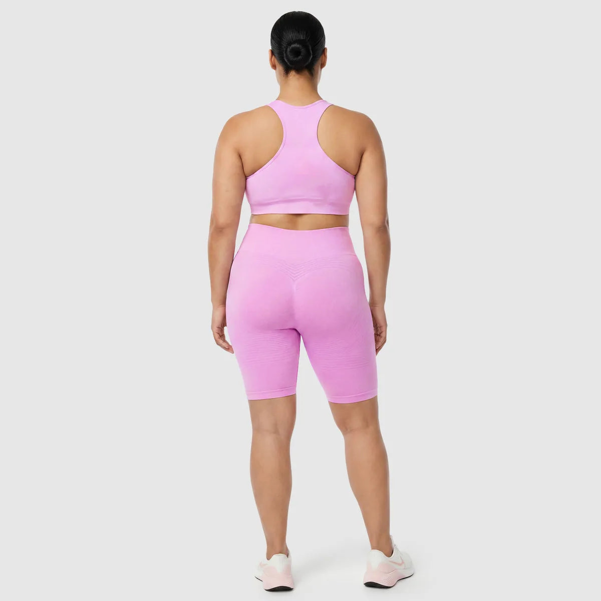 Kvinna i Sculpt 3D™ anticellulitshorts i rosa, bakifrån, lyft och formad rumpa