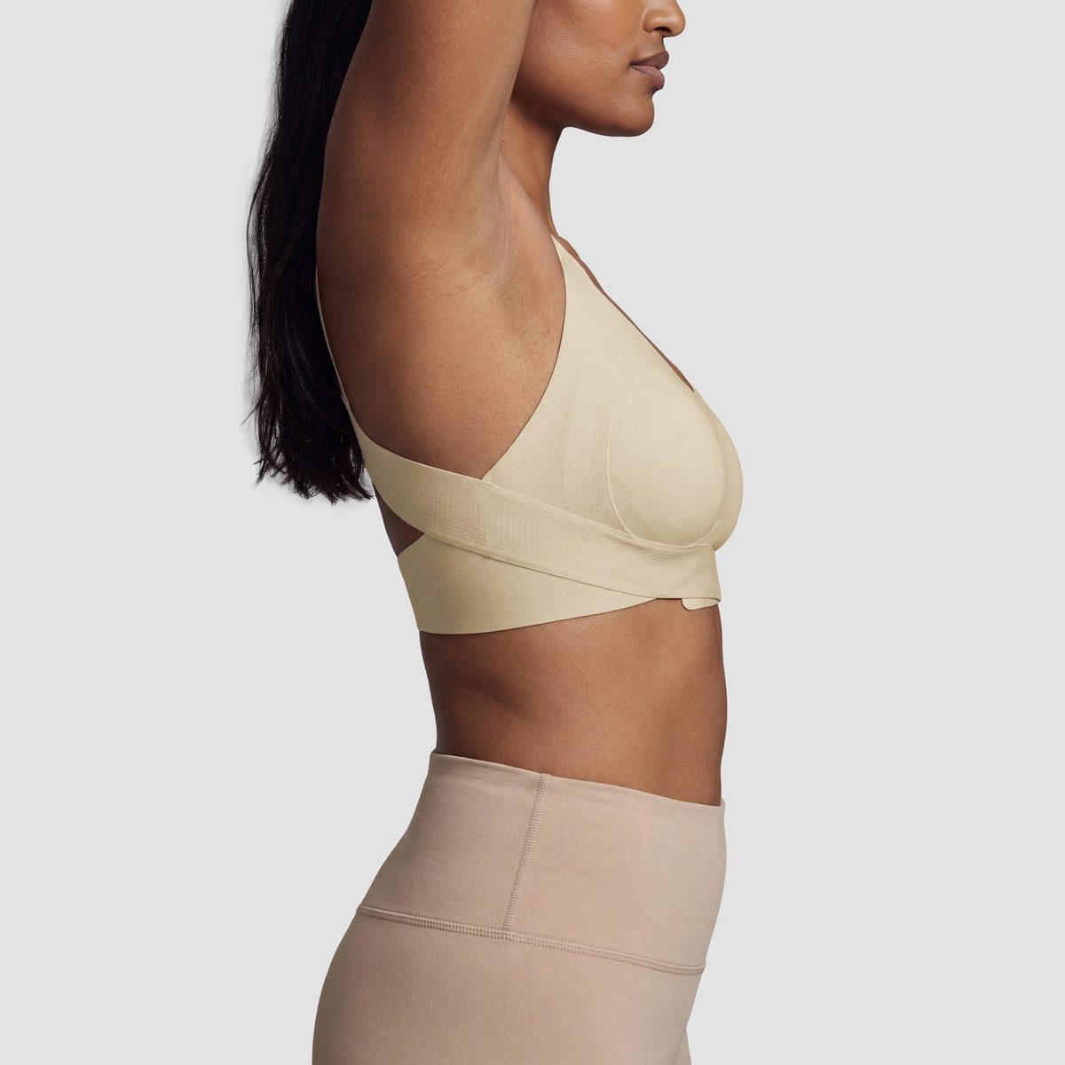Sculpt hållnings-bh i beige, från sidan med armen lyft för att visa den trådlösa passformen